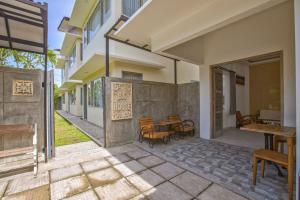 a patio with a table and chairs and a building at ImahBC Surfcamp in Tabanan