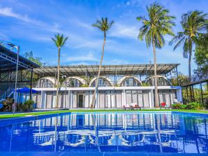 una piscina frente a un edificio con palmeras en Adventure Dome Resort en Kep