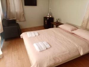 a bedroom with a large white bed with towels on it at Homey Hut Ayutthaya in Phra Nakhon Si Ayutthaya