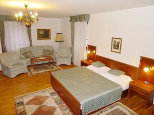 Hotel Nosal في براغ: غرفة نوم مع سرير وغرفة معيشة مع أريكة