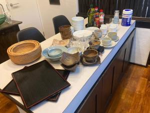 stół z miskami i naczyniami na górze w obiekcie ゲストハウスナゼ w mieście Amami