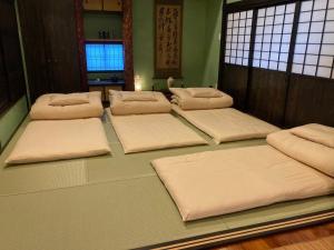 een groep kussens op de vloer van een kamer bij ゲストハウスナゼ in Amami