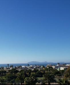 Blick auf eine Stadt mit Palmen und das Meer in der Unterkunft Departamentos vacacionales in Rosarito