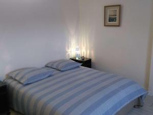 トレガステルにあるAppartement Trégastel, 3 pièces, 6 personnes - FR-1-368-52のベッドルーム1室(青と白のストライプのベッド1台付)