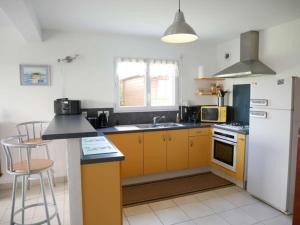 eine Küche mit gelben Schränken und einem weißen Kühlschrank in der Unterkunft Villa Erdeven, 5 pièces, 8 personnes - FR-1-479-14 in Erdeven