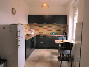 eine Küche mit einem Kühlschrank und einem Tisch mit Stühlen in der Unterkunft Maison rénovée 100m mer avec WIFI, jardin à Trégastel - FR-1-368-296 in Trégastel + 7 Fotos