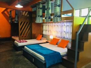 two beds in a room with orange and blue at Casa San Pablo B & B in San Pablo
