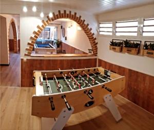 una mesa de futbolín de madera en una habitación con arco en Lilie location langevin, en Saint-Joseph