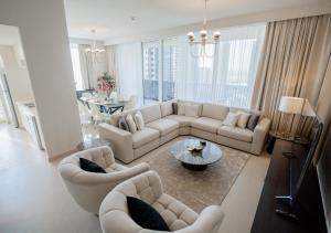uma sala de estar com sofás e uma mesa em Nasma Luxury Stays - Harbour Gate Tower 1 em Dubai