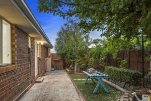 uma mesa de piquenique azul no quintal de uma casa em Corner Cottage em Dandenong