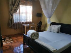 Un dormitorio con una cama grande y una ventana en The Roots classic hotel, en Njeru