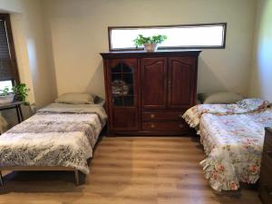 Habitación con 2 camas y armario con ventana en Arrowhead Country Home, en Crestline