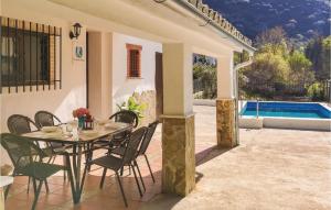eine Terrasse mit einem Tisch, Stühlen und einem Pool in der Unterkunft Amazing Home In Benamahoma With Outdoor Swimming Pool in Benamahoma