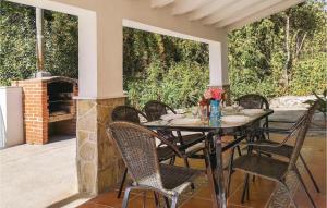 einen Tisch und Stühle auf einer Terrasse mit Kamin in der Unterkunft Amazing Home In Benamahoma With Outdoor Swimming Pool in Benamahoma