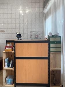 una habitación con un mostrador con una puerta y algunos estantes en Nuan Hostel en Xiaoliuqiu