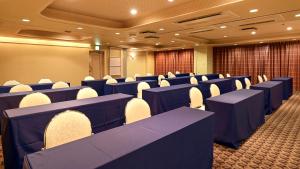 una sala conferenze con tavoli e sedie blu di Hotel Global View Tsuchiura a Tsuchiura
