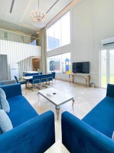 a living room with blue couches and a tv at شاليه رويال الخبر - Royal Resort AL Khobar in Al Khobar