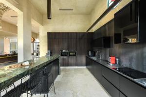 a large kitchen with black cabinets and green counter tops at The Pearl of Jaffa Lux Apartment by Sea N' Rent in Tel Aviv