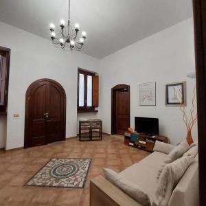 ein Wohnzimmer mit einem Sofa und einem Kronleuchter in der Unterkunft Nel Cuore del Barocco in Lecce
