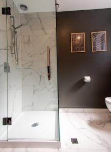 a bathroom with a shower and a toilet and a sink at New Boutique Central Sanctuary near Latimer Square in Christchurch