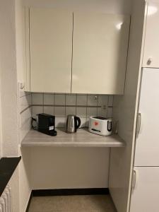 a kitchen counter with two toasters and a toaster at Comfort 1 and 2BDR Apartment close to Zurich Airport in Zurich
