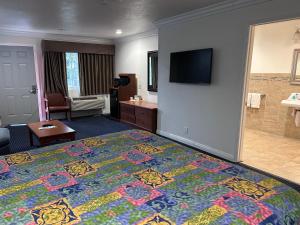 a hotel room with a king sized bed and a bathroom at Willow Tree Lodge in Fullerton