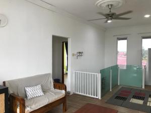 Bendang Homes - Sekinchan Homestay في Kampong Sungai Leman: غرفة معيشة مع أريكة ومروحة سقف