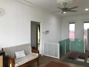 a living room with a couch and a ceiling fan at Bendang Homes - Sekinchan Homestay in Kampong Sungai Leman