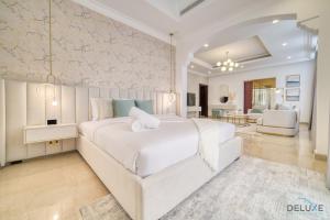ドバイにあるSignature 6BR Villa with Assistant Room and Private Pool in Frond F Palm Jumeirah by Deluxe Holiday Homesの白いベッドルーム(大型ベッド1台付)、リビングルームが備わります。 +79枚の写真