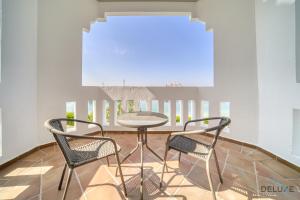 ドバイにあるSignature 6BR Villa with Assistant Room and Private Pool in Frond F Palm Jumeirah by Deluxe Holiday Homesのテーブルと椅子2脚のあるダイニングルーム