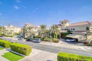 ドバイにあるSignature 6BR Villa with Assistant Room and Private Pool in Frond F Palm Jumeirah by Deluxe Holiday Homesのヤシの木が茂る建物前の通り
