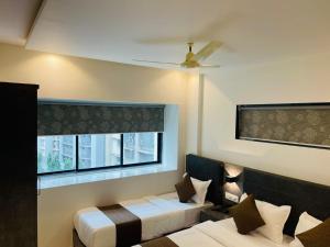 ムンバイにあるHOTEL BLACK BURNのベッド2台と窓が備わる客室です。