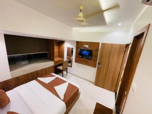 a hotel room with a bed and a tv at HOTEL BLACK BURN in Mumbai
