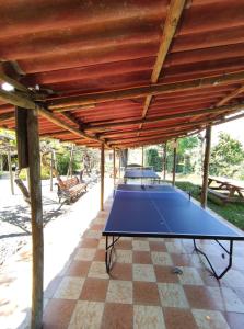 una mesa de ping pong bajo un pabellón de madera en Glamping Remanso del Espíritu en Isla de Maipo