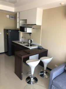 a kitchen with a sink and two bar stools at Mai Khao Beach Apartments -MBC- in Ban Bo Sai Klang