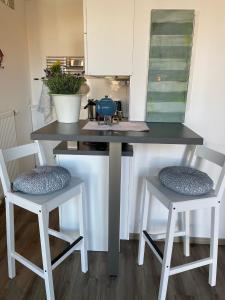una cocina con 2 sillas y una mesa con barra en Kapitänshaus mit Hafenblick en Greetsiel