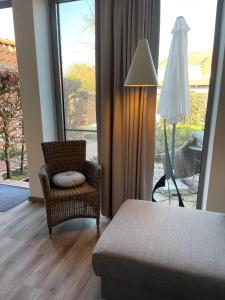 Habitación con silla, lámpara y ventana en Kapitänshaus mit Hafenblick en Greetsiel