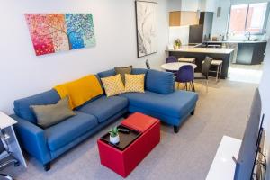 a living room with a blue couch and a kitchen at Peaceful Central City 2 bed pad w/carpark in Christchurch