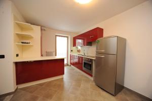 ペーイオにあるAppartamenti Vegaiaのキッチン(赤いキャビネット、ステンレス製の冷蔵庫付)