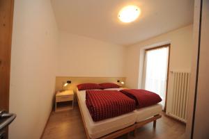 ペーイオにあるAppartamenti Vegaiaのベッドルーム1室(赤い枕のベッド1台、窓付)