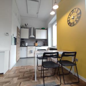 una cocina con mesa y sillas y un reloj en la pared en Krokus, en Sokołowsko