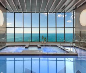 a large swimming pool with a view of the ocean at Surfers Paradise New Beachfront Apartments in Gold Coast