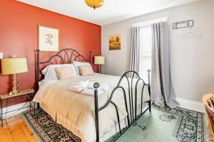 a bedroom with red walls and a bed with a wrought iron headboard at Ye Olde Walkerville Bed & Breakfast in Windsor