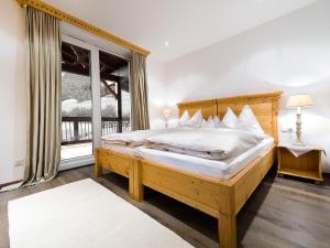 ein Schlafzimmer mit einem Holzbett und einem Fenster in der Unterkunft Kasperhof Apartments Innsbruck Top 6 - 7 in Innsbruck