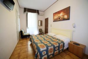 a bedroom with a bed with a colorful blanket on it at Hotel Giugiù in Rome