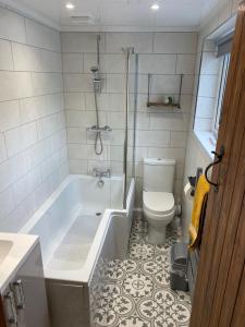 a bathroom with a bath tub and a toilet at Tegfan Victorian terrace Cottage Snowdonia Llanberis in Llanberis
