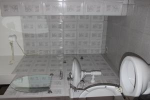 a bathroom with a toilet and a sink and a mirror at Sky Hotel International in Kampala