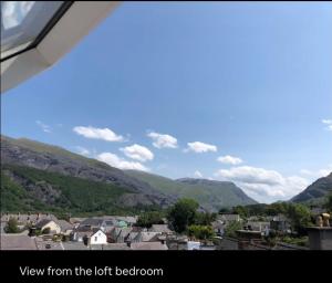 een uitzicht vanaf het linkerbalkon van een stad met bergen bij Tegfan Victorian terrace Cottage Snowdonia Llanberis in Llanberis