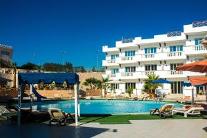 un hôtel avec une piscine en face d'un bâtiment dans l'établissement Palma Di Sharm Hollywood Aqua Park Resort, à Charm el-Cheikh