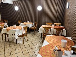 um restaurante com mesas e cadeiras num quarto em Hotel Schwan em Hügelsheim